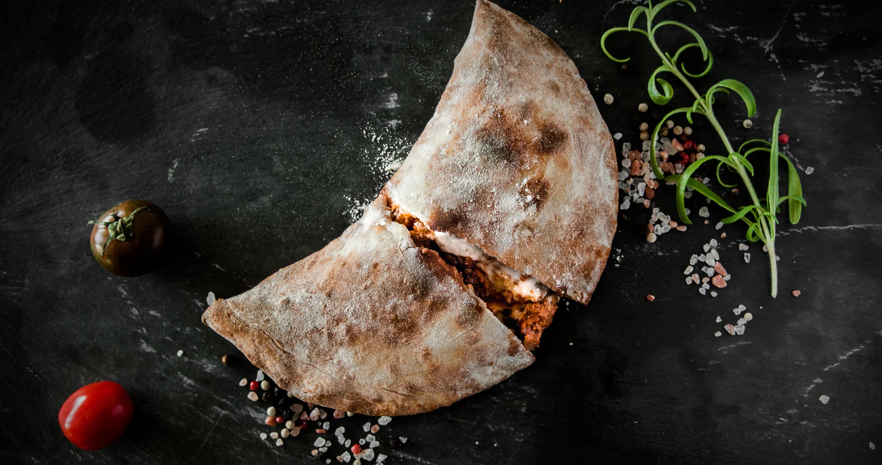 Original Calzagna prototype, cut open to show lasagna inside its flour-dusted baked crust